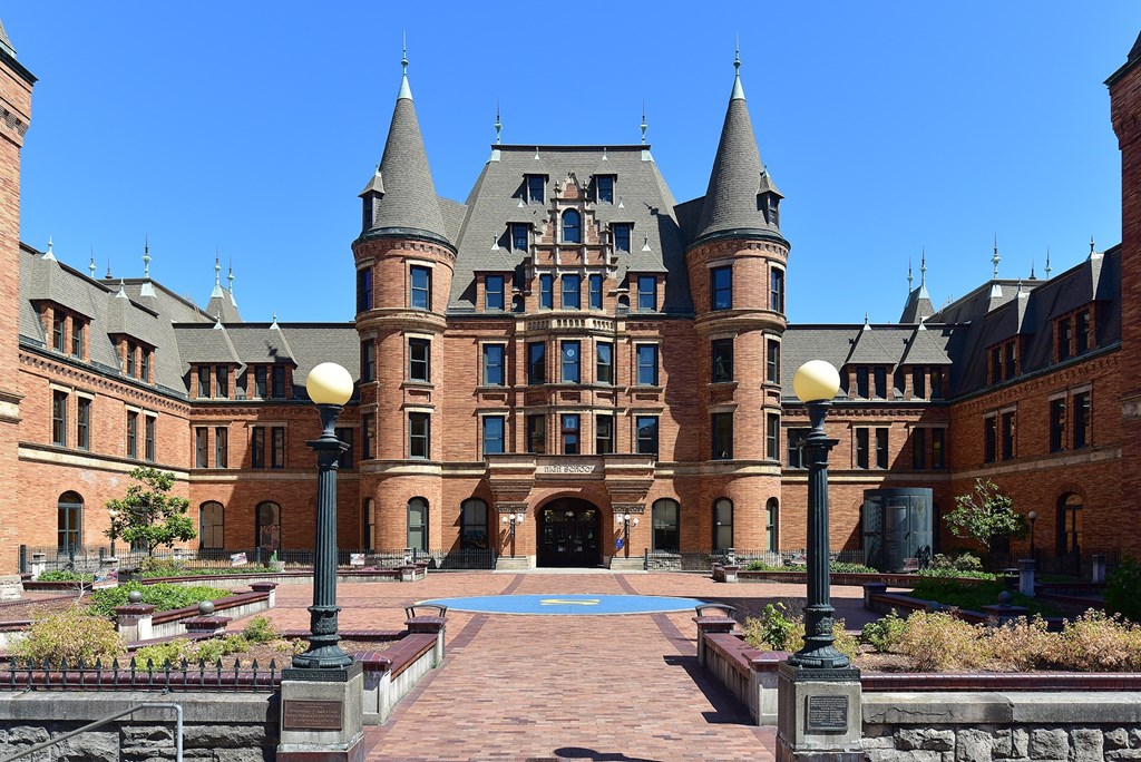 A large castle-like building with a courtyard in front.