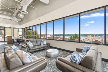 A living room with two couches and a large window overlooking a cityscape.