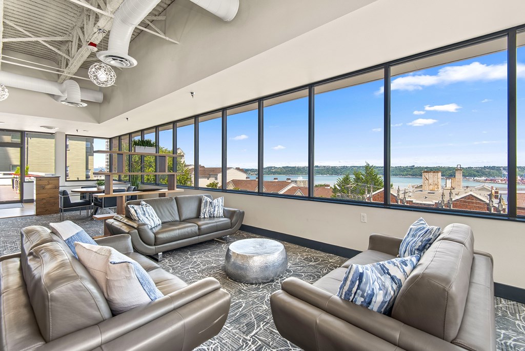 A living room with two couches and a large window overlooking a cityscape.