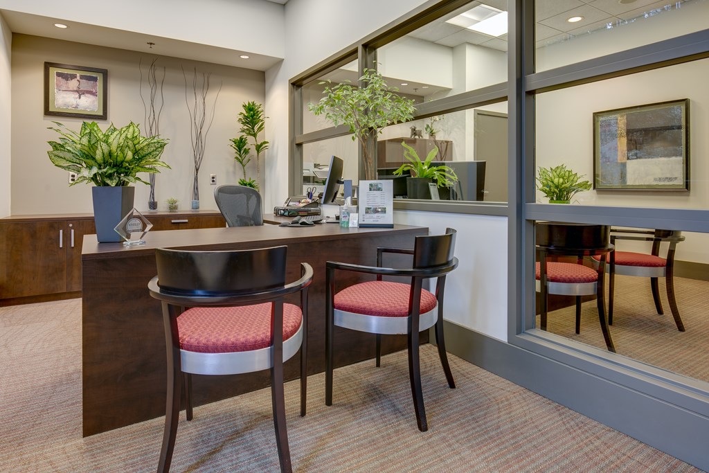 A reception area with a desk and two chairs.