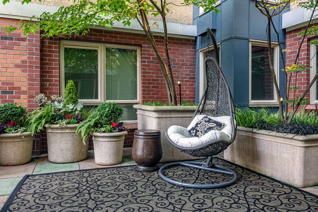 A chair sits on a patio with a brick wall behind it.