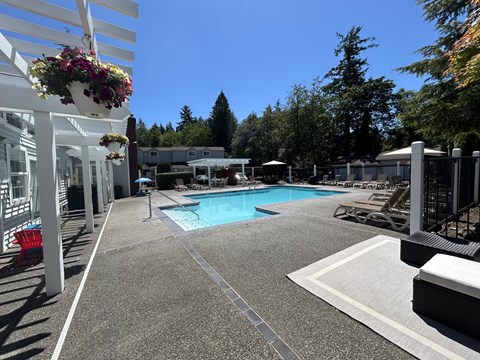 A pool area with a white fence and a red chair.