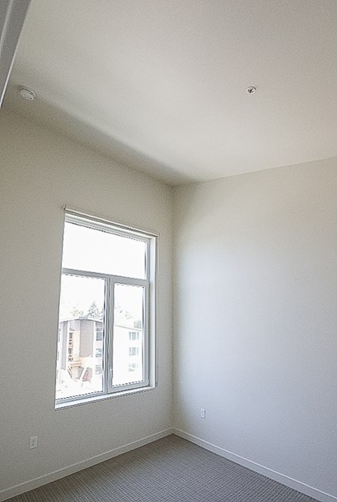 A room with a window and a view of a building outside.