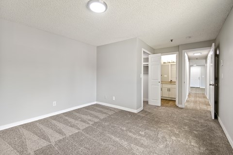 A spacious room with a carpeted floor and white walls.