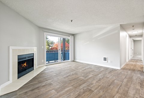 A modern living room with a fireplace and sliding glass doors.