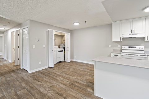 A kitchen with white cabinets and a white counter top.