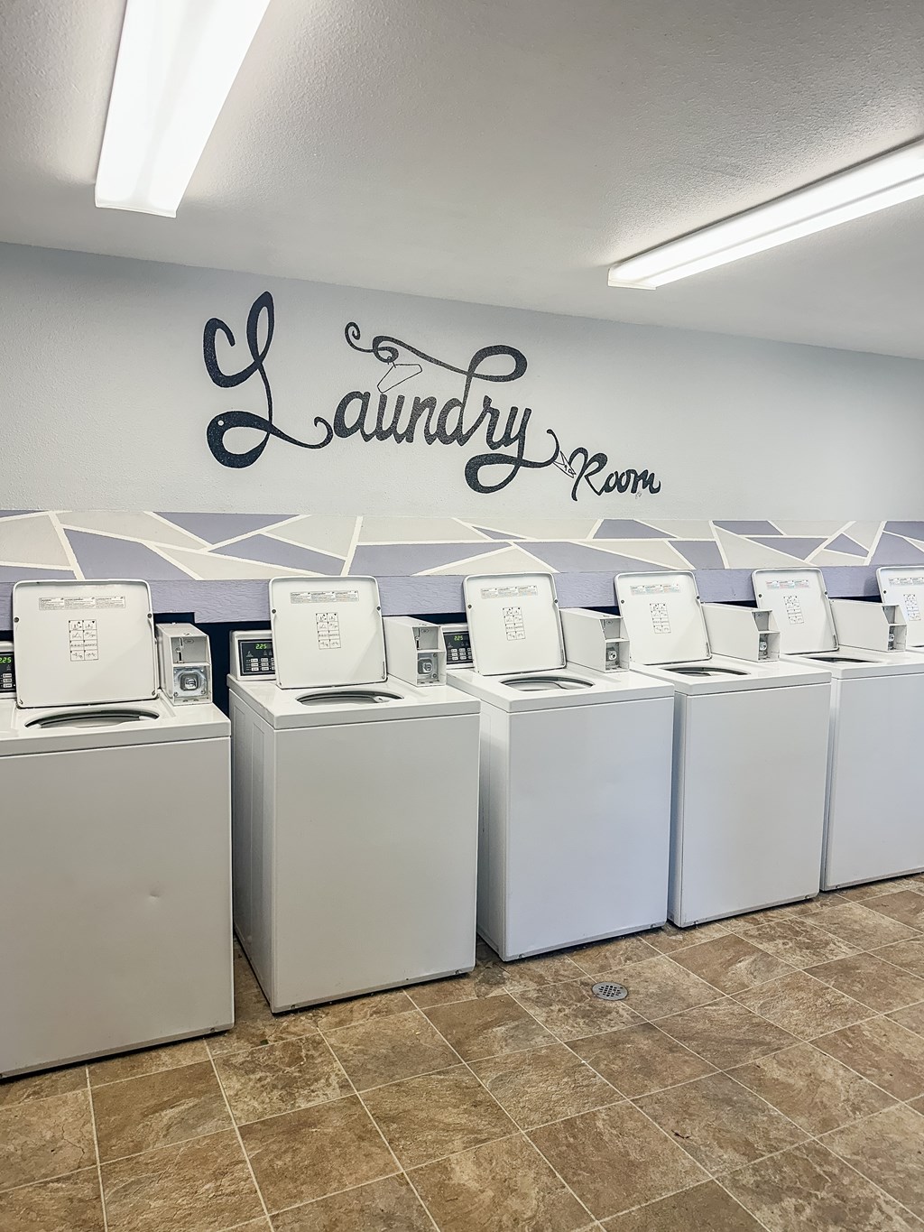 A laundry room with washing machines and a wall sign.