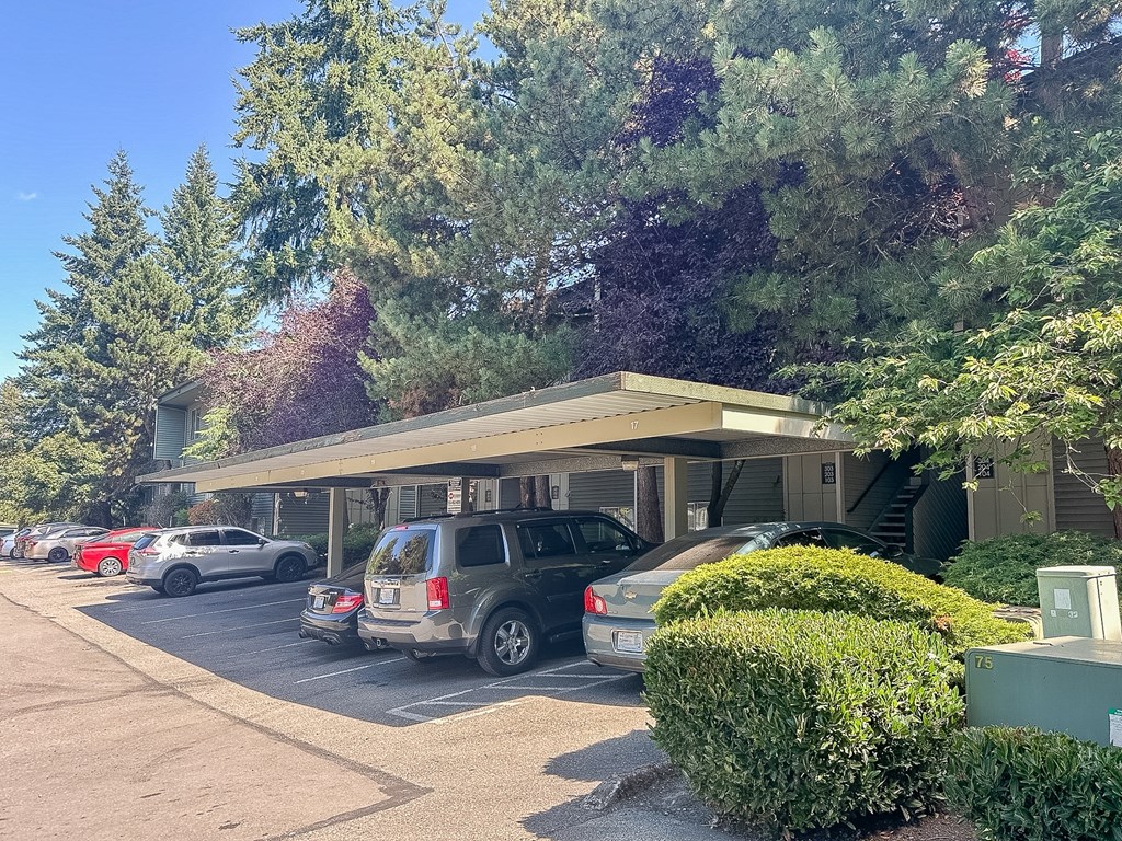 A parking lot with cars and a building in the background.