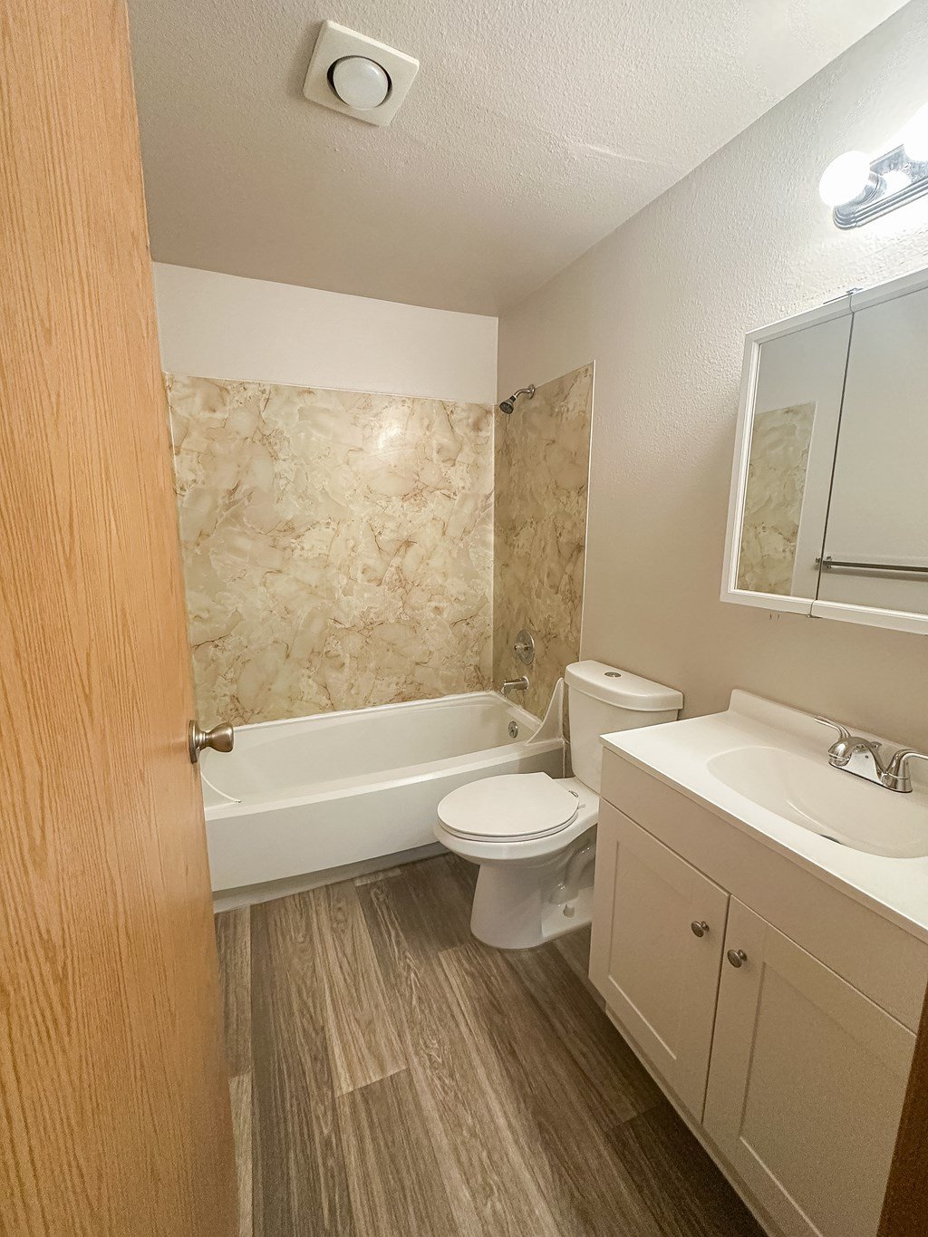 A bathroom with a toilet, sink, and bathtub.