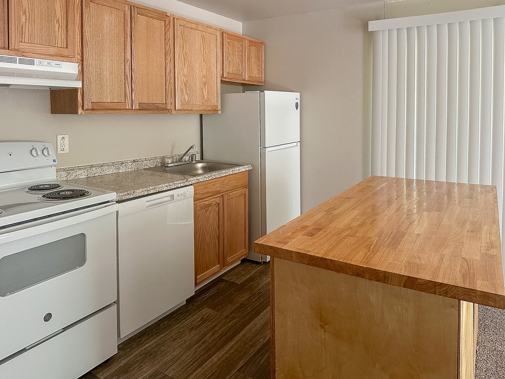 A kitchen with wooden cabinets and a white refrigerator.