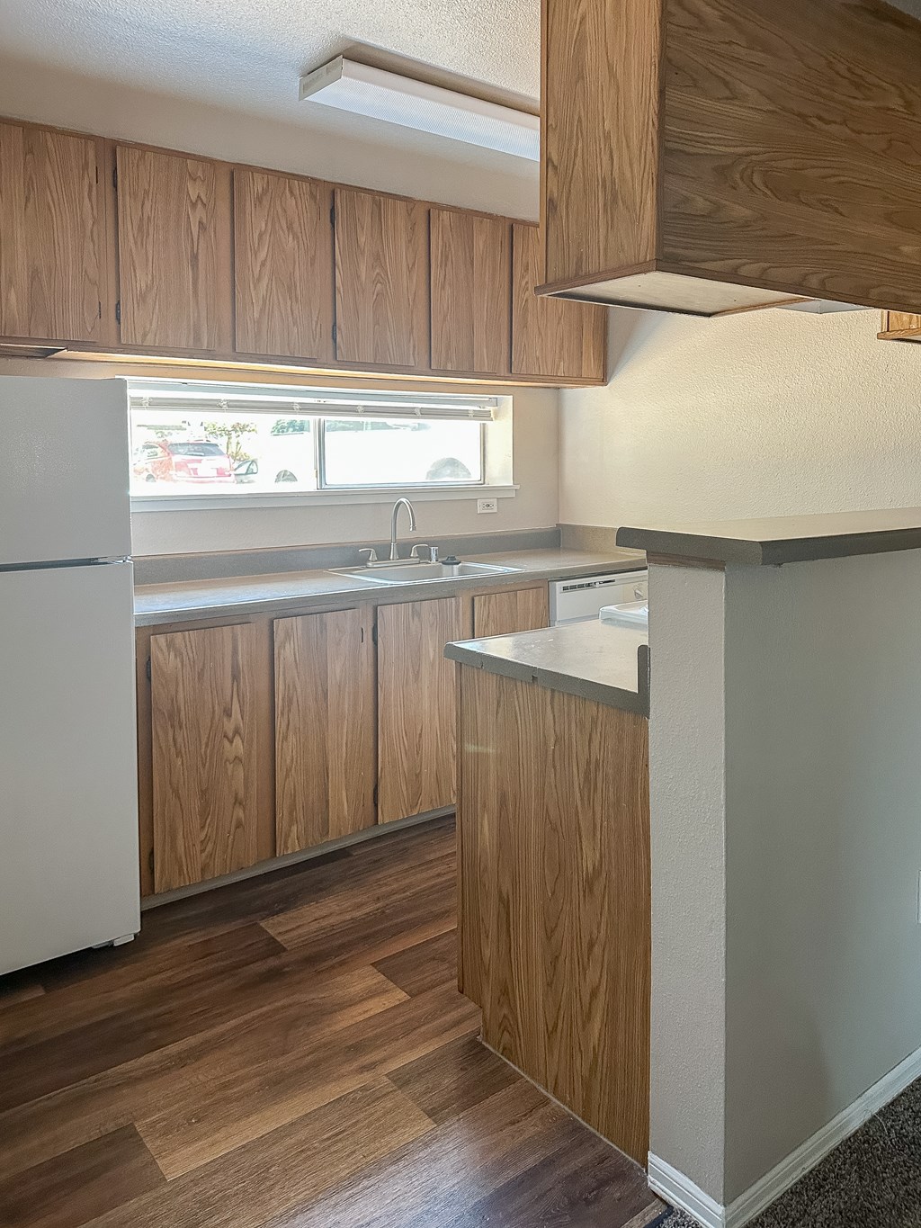 A kitchen with wooden cabinets and a white refrigerator.
