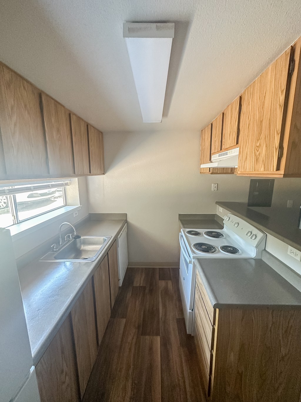 A kitchen with a stove top oven and a sink.