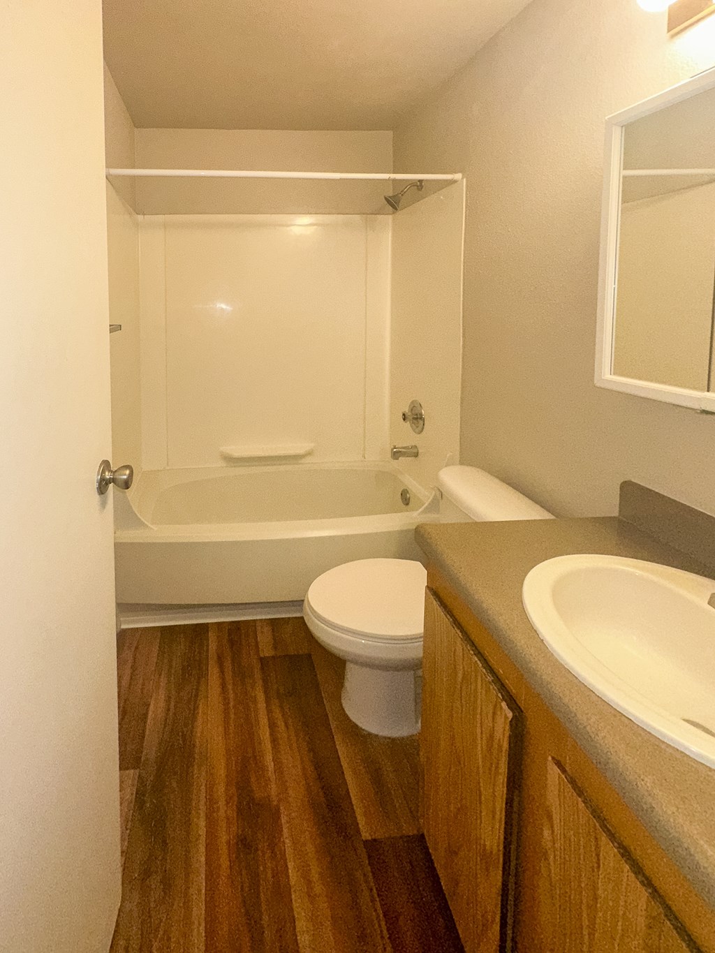 A white toilet sits in a bathroom next to a bathtub.