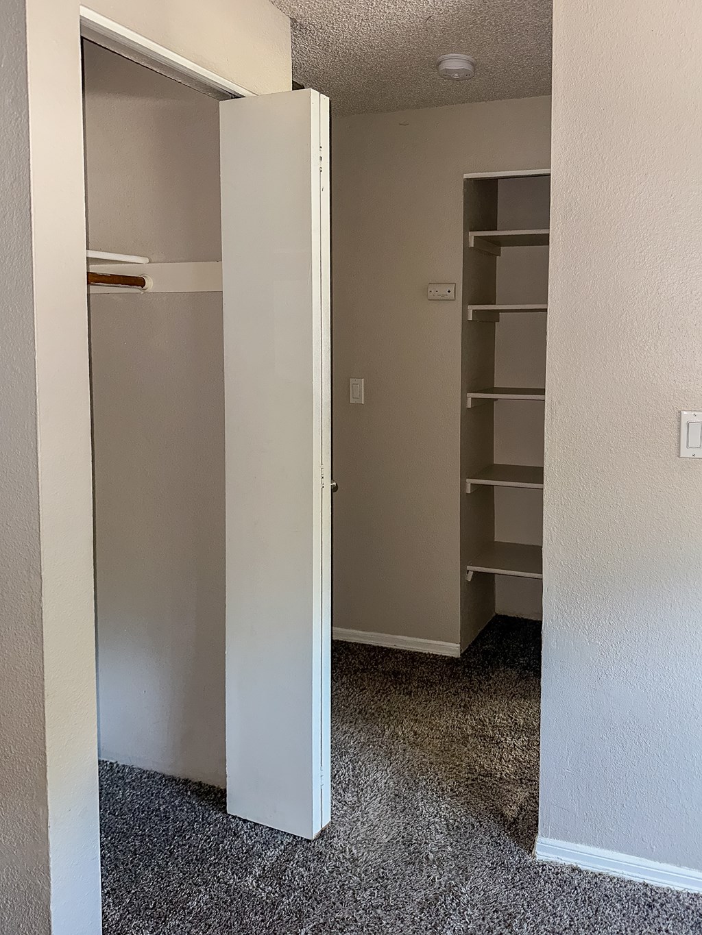 A white door is open to a room with a carpeted floor.