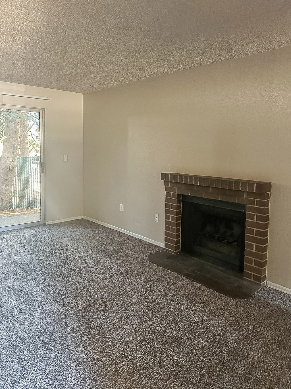 A room with a fireplace and carpeted floor.