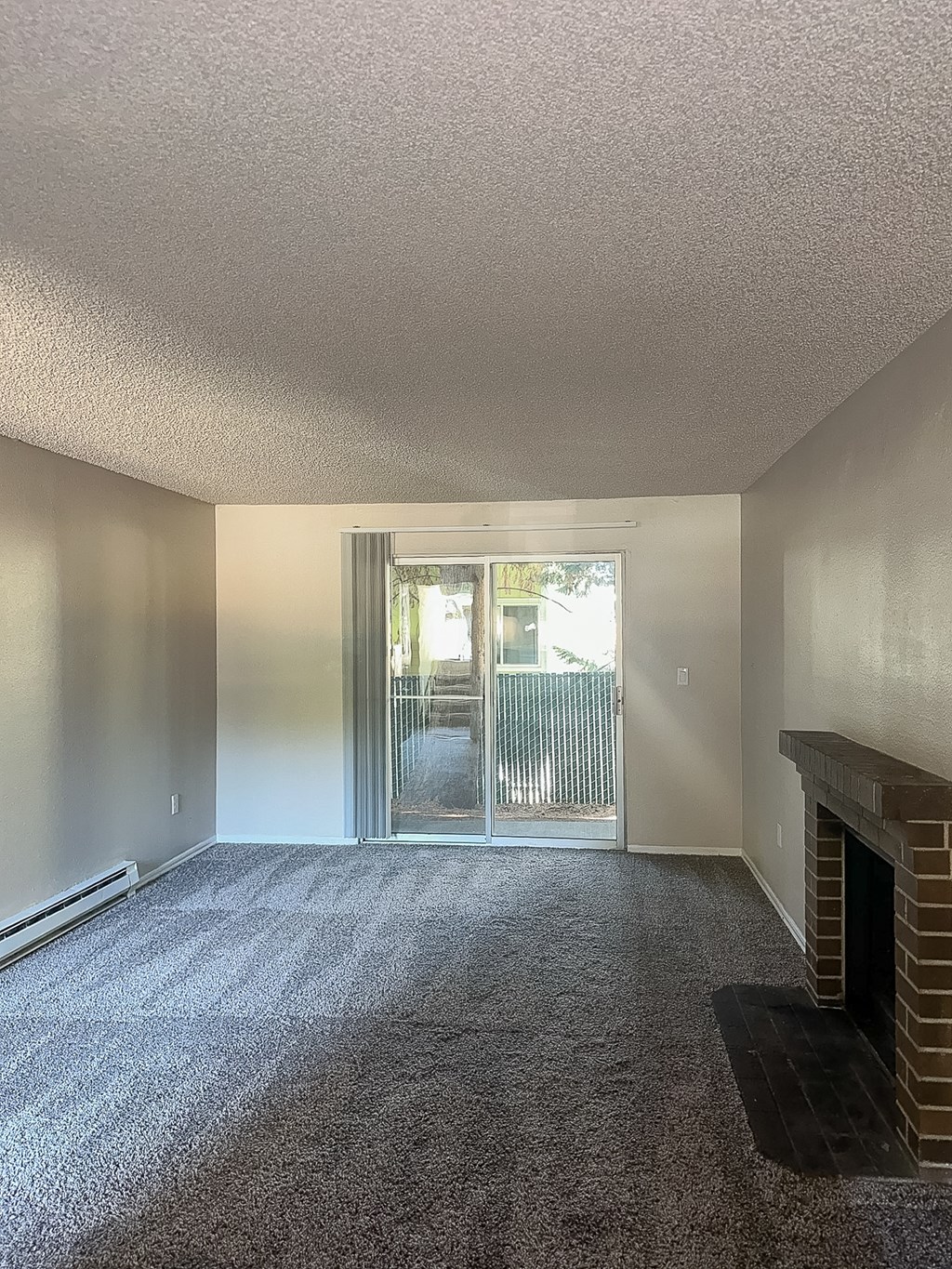 A room with a fireplace and a carpeted floor.