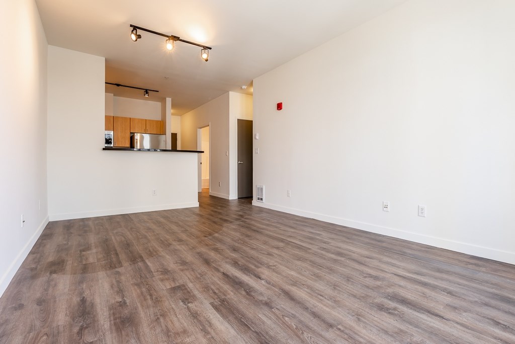 A room with wooden flooring and white walls.