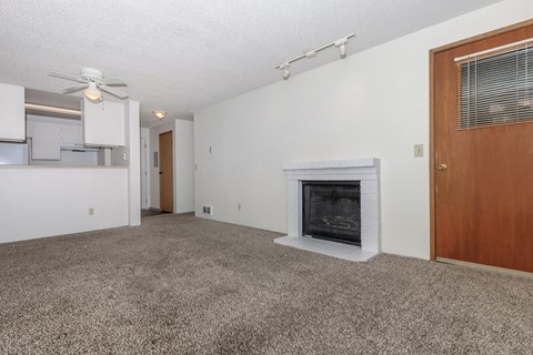 A living room with a fireplace and a ceiling fan.