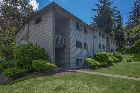 A modern two-story apartment building with a balcony on the second floor.