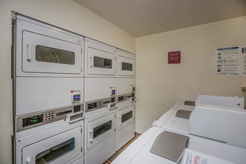 A row of white ovens are lined up in a room.