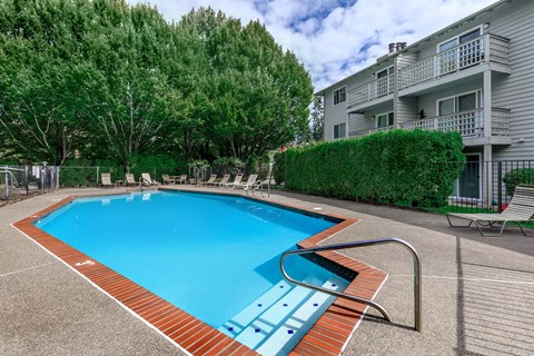 A small pool with a red border and a metal railing.