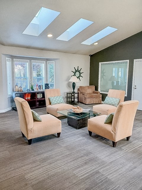 A living room with a glass table and four chairs.
