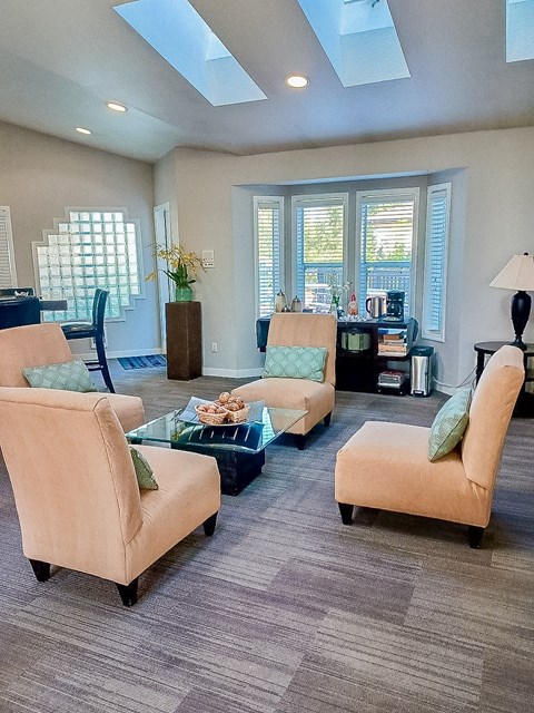 A living room with a glass table and four chairs.