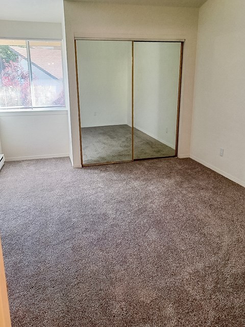 A room with a carpeted floor and a sliding glass door.