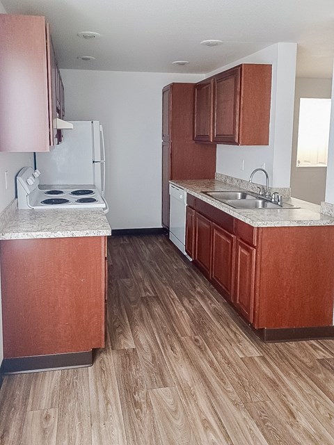 A kitchen with wooden cabinets and a white stove top oven.
