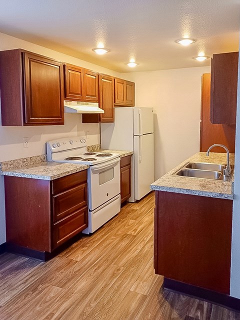 A kitchen with wooden cabinets and a white refrigerator.