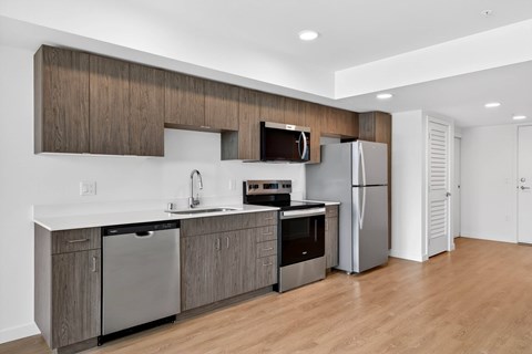 A modern kitchen with wooden cabinets and stainless steel appliances.