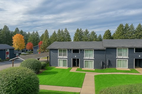 A row of houses with green lawns in front.