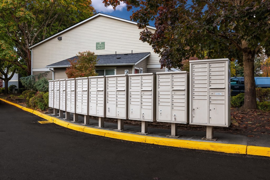 A row of mailboxes in front of a house.