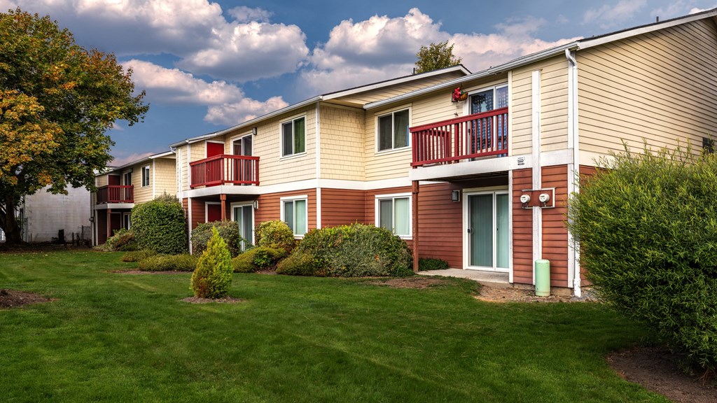 A row of houses with green lawns in front.