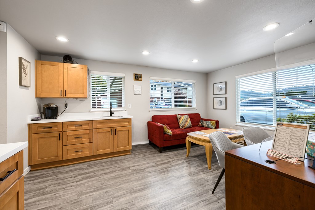 A well-lit room with a red couch and wooden furniture.