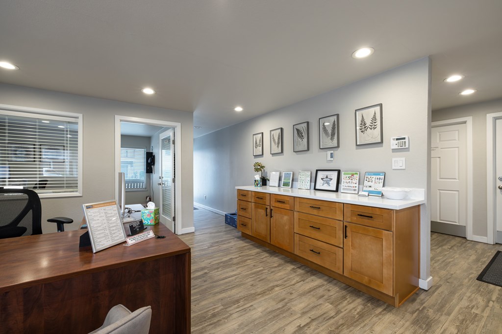 A reception area with a wooden desk and a white receptionist's chair.