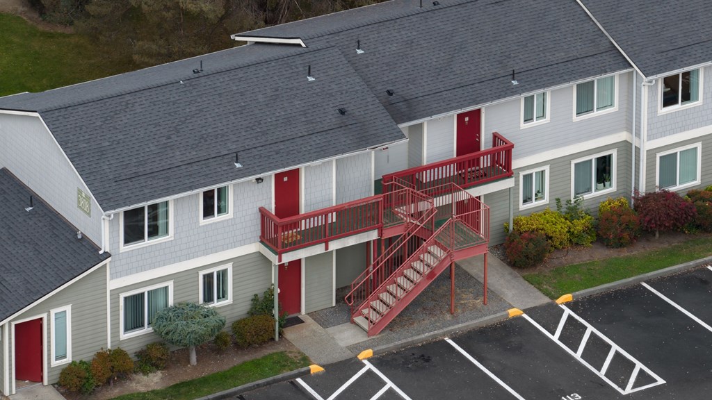 A red staircase is attached to a grey building.