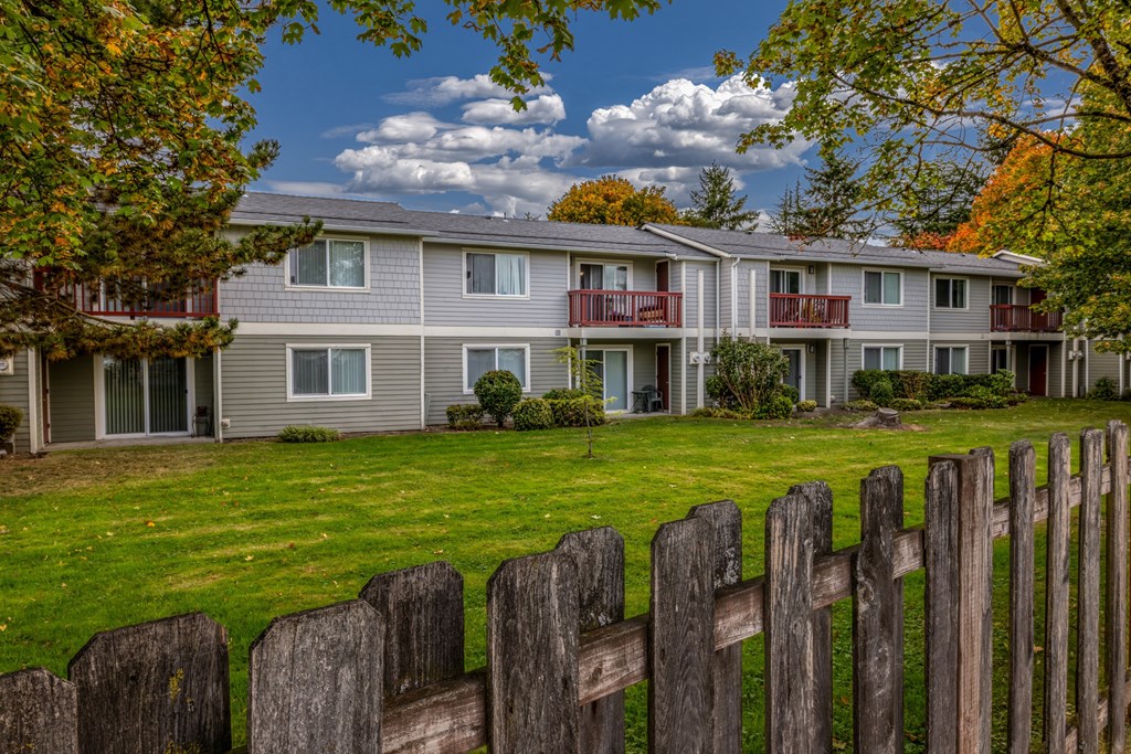 A row of houses with a wooden fence in front.