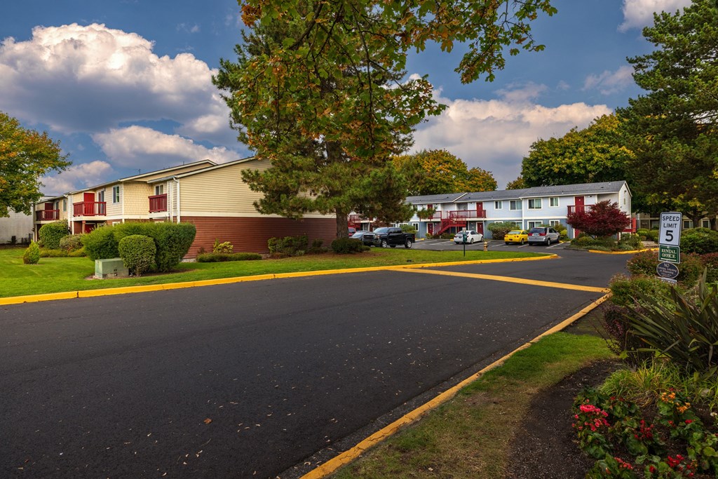 A street view of a residential area with houses and trees.