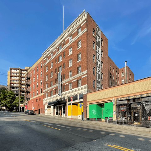 A large red brick building with the words "NY PYTHON HOTEL" on the side.