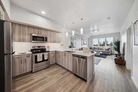A modern kitchen with wooden cabinets and a stainless steel refrigerator.