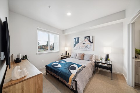 A bedroom with a bed, nightstand, and a television.