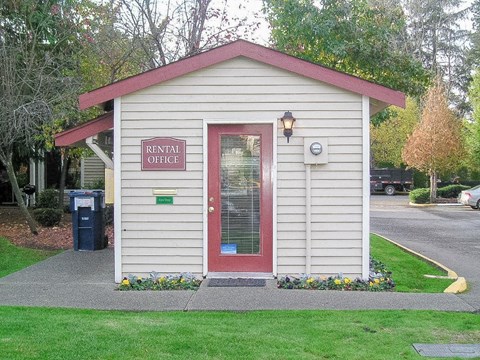 A small building with a red door and a sign that says RENTAL OFFICE.