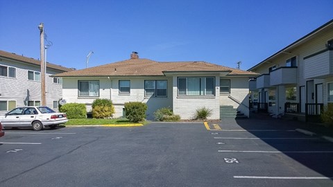 A parking lot with a car parked in front of a building.