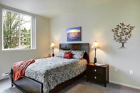 A bedroom with a large bed and a painting on the wall.