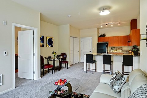 A living room with a white couch and a bar area.