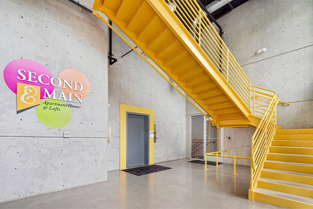 A staircase with a yellow railing and steps leads up to a door.