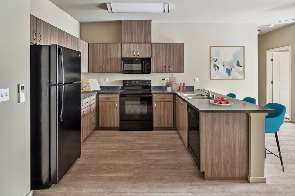 A kitchen with black appliances and wooden cabinets.