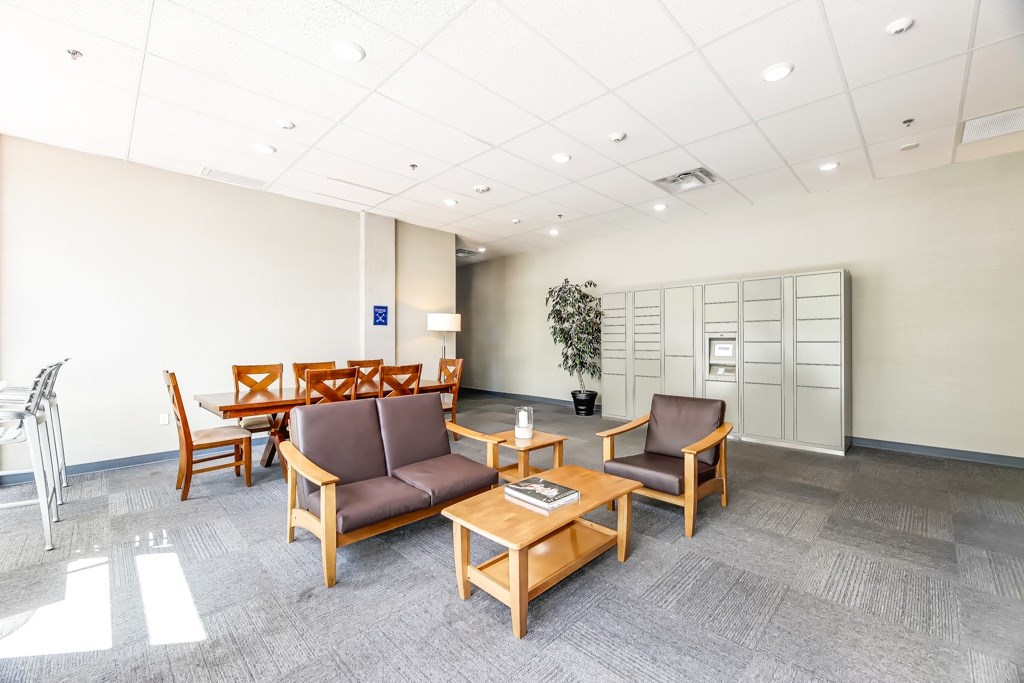 A waiting room with brown chairs and a wooden table.