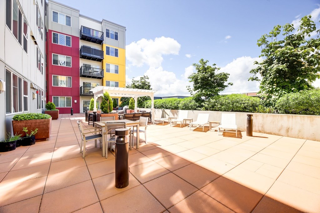 A patio with a table and chairs is surrounded by apartment buildings.